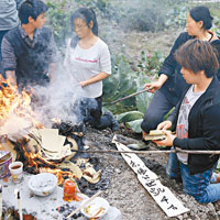 家屬焚燒冥鏹拜祭遇難親人。（中新社圖片）