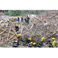 消防員於瓦礫中搜救死傷者。　（中新社圖片)