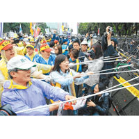 台灣<BR>示威民眾用麻繩圖拉倒警方架設的鐵馬。（中央社圖片）