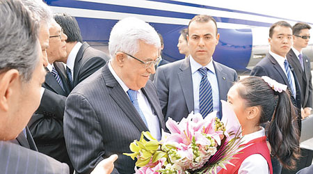 阿巴斯（中）飛抵北京時獲一名女童獻花。（中新社圖片）