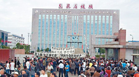 大批村民手持橫額到涉事煤礦公司門前示威。