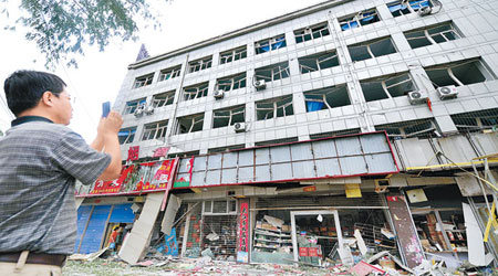 爆炸飯店對面的辦公樓的門窗均被震碎扭曲。（中新社圖片）