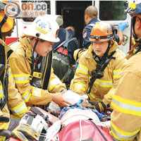 消防員將昏迷的華裔男子送上救護車。（本報美國傳真）