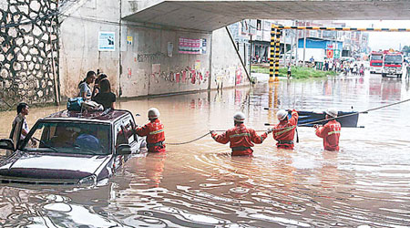 廣西<br>消防員搶救被洪水圍困車輛的乘客。（中新社圖片）