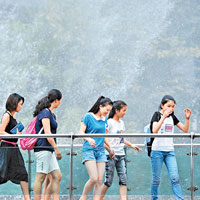 重慶<BR>重慶市有多名市民在噴泉前納涼。（中新社圖片）