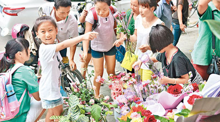 不少學童到花店選購鮮花送贈老師。（中新社圖片）