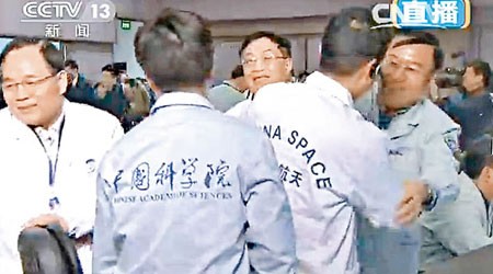 北京航天飛控中心工作人員相擁慶祝嫦娥三號成功登陸月球。（中新社圖片）