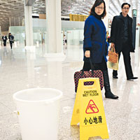 旅客側目<br>旅客經過接水的白色大桶亦不禁側目。（中新社圖片）