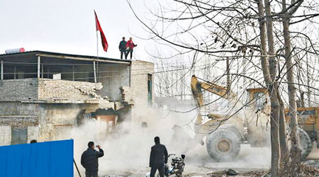 王站在天台抗議強拆，當局出動挖土機強拆。（互聯網圖片）