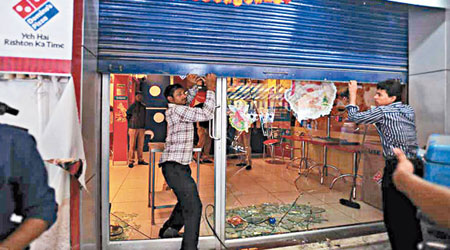印度孟買有示威者闖入達美樂薄餅店，砸毀玻璃門，大肆破壞。（互聯網圖片）