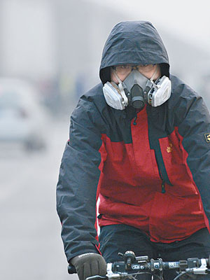 北京市民戴防毒面具騎單車出行。（中新社圖片）