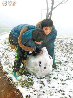 新竹縣新光部落有小學生於上學途中堆雪人。（本報新竹傳真）