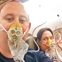 兩名乘客戴上氧氣罩後自拍，並將相片上載至互聯網。（互聯網圖片）