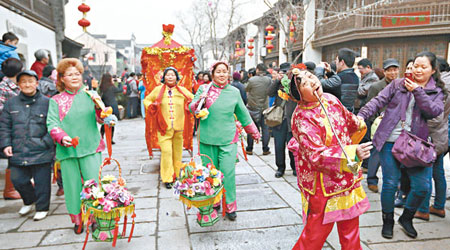 江蘇南京有民族隊伍在大街上巡遊表演，逗得遊人笑彎了腰。（中新社圖片）