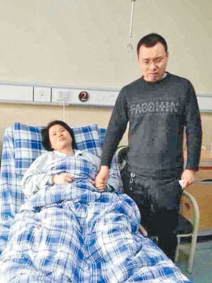 王姓女護士受傷臥床，丈夫神情哀傷。（互聯網圖片）