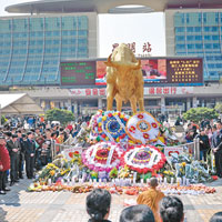 昆明火車站外廣場銅牛像下擺滿花圈。（中新社圖片）