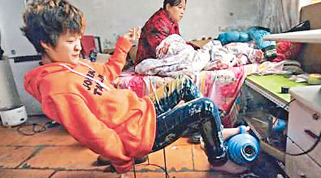 趙娜照顧半癱的母親，用雙腳倒出熱水壺內的熱水。（互聯網圖片）