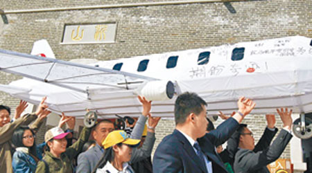 中國山東的民眾在飛機模型上寫下祝福字句，希望失蹤同胞歸來。（中新社圖片）