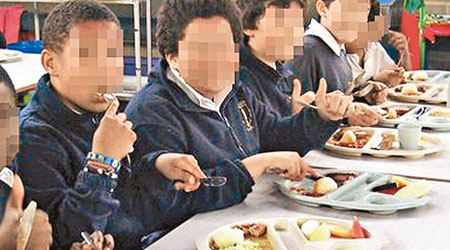學生們食飯時按膚色深淺而坐。（互聯網圖片）