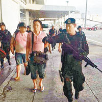 班通達（右二）在軍人押送下向軍方報到。（互聯網圖片）