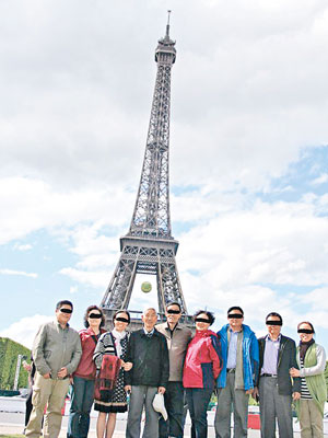 受傷老翁（左四）遇劫前曾與團友在巴黎鐵塔前留影。（互聯網圖片）