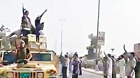 疑似ISIL武裝分子高舉槍枝，在煉油廠附近慶祝。（互聯網圖片）