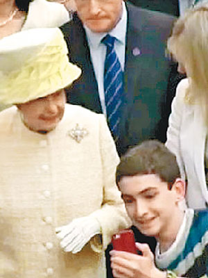 瑟奇諾（右）突然從人群跳出，拿手機與英女王自拍。（互聯網圖片）