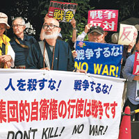 示威者舉起「行使集體自衞權等同發起戰爭」等反戰標語。（中新社圖片）