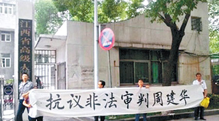 周建華家屬在江西高院門口拉橫額喊冤。 （互聯網圖片）