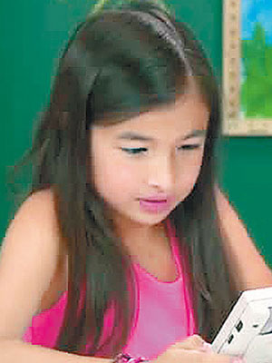 有女童試玩Game Boy，對其粗糙畫面不禁皺眉。（互聯網圖片）