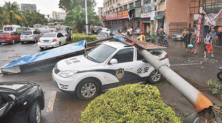海口市強風吹塌電線杆壓毀警車。　（互聯網圖片）