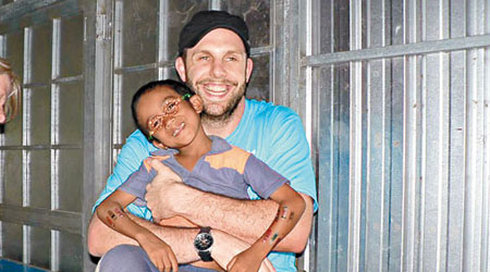萊納在柬埔寨與當地兒童打成一片。（互聯網圖片）