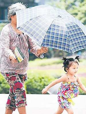 重慶有家長為小孩撐傘出行。（互聯網圖片）