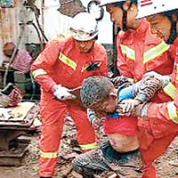 消防員從瓦礫中挖出一名男童。（互聯網圖片）