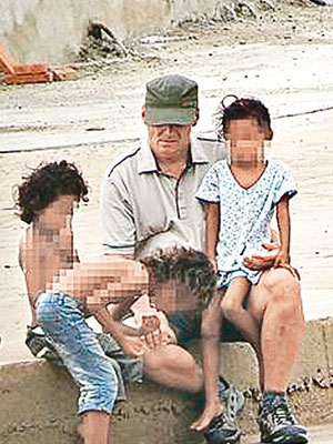 一名女童坐在瓊斯大腿，另外兩名女童上半身赤裸。（互聯網圖片）