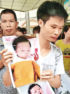 男嬰父親拿着兒子的照片。（互聯網圖片）