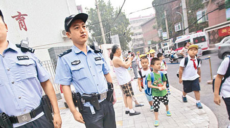 山東濟南市警方安排佩槍警員在學校門口執勤。（中新社圖片）