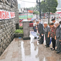 遇難者家屬和市民冒雨默哀。（中新社圖片）