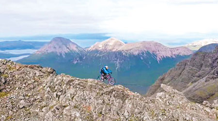 麥阿斯基爾在崎嶇狹窄的山路上騎單車前行，沿途風景秀麗。（互聯網圖片）