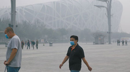 北京<br>因大霧籠罩，北京奧林匹克公園遊客戴上口罩。（中新社圖片）
