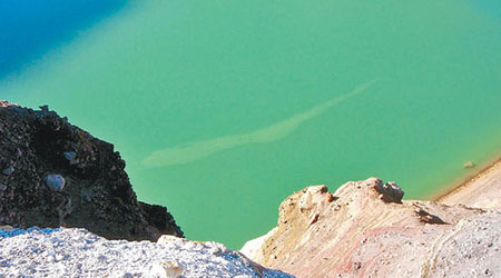 調查小組發現山頂的火口湖湖面，出現白色污染帶。（互聯網圖片）