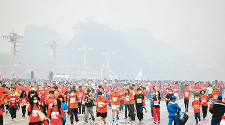 北京馬拉松昨在霧霾籠罩下照樣開賽，半空一片朦朧。（互聯網圖片）