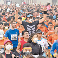 很多跑手都戴上口罩參賽。（中新社圖片）
