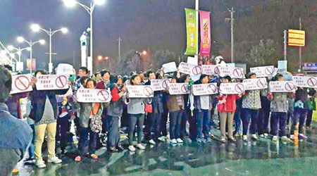 大批示威者手持標語反對興建電池廠。（互聯網圖片）