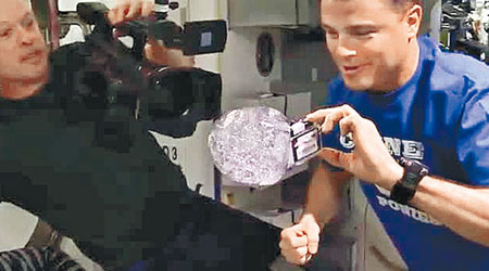 太空人把相機放入水滴中。（互聯網圖片）