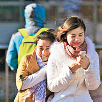 北京街頭行人身穿厚重冬裝抵禦寒風。（互聯網圖片）