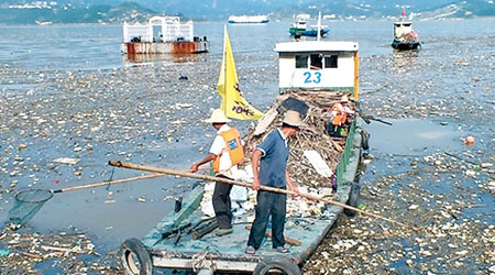 清潔工人早前在三峽大壩近壩水域打撈漂浮物。（互聯網圖片）
