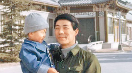 李望知（手抱男童）與父親薄熙來三十多年前的合照。（互聯網圖片）