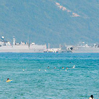 三亞<br>海南一個海濱浴場緊鄰三亞軍港，核潛艇驅護艦清晰可見。（互聯網圖片）