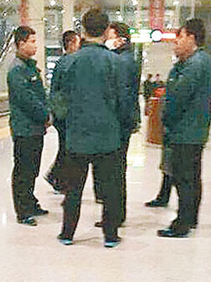 網上流傳楊衞澤（戴口罩者）被中紀委人員包圍，在站台候車。（互聯網圖片）